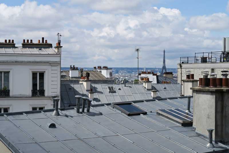 Iconic zinc rooftops of Paris seen above classic Haussmann-style buildings