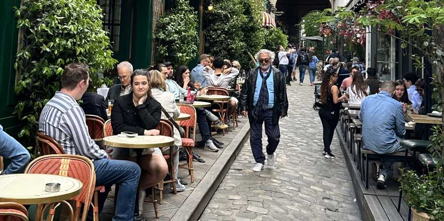 Paris street style is not always about dressing up. Sometimes one person has a more striking, effortless look, while everyone around them is dressed casually in jeans, simple jackets, and sneakers. That mix is very typical for everyday Paris.